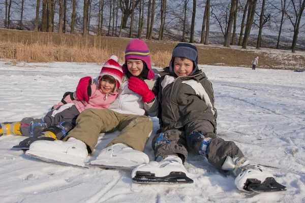 Crianças de patinação diversão na neve — Fotografia de Stock