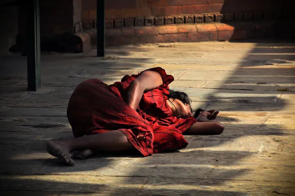 Stock image Woman sleeping at walls of hindu temple