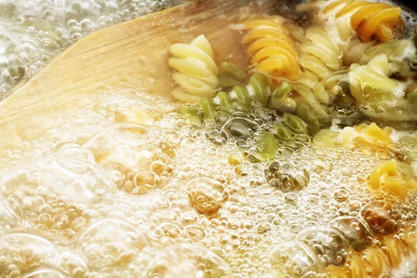Pâtes en spirale dans l'eau bouillante chaude — Photo