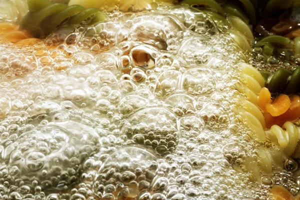 Спиральная паста в кипящей воде — стоковое фото