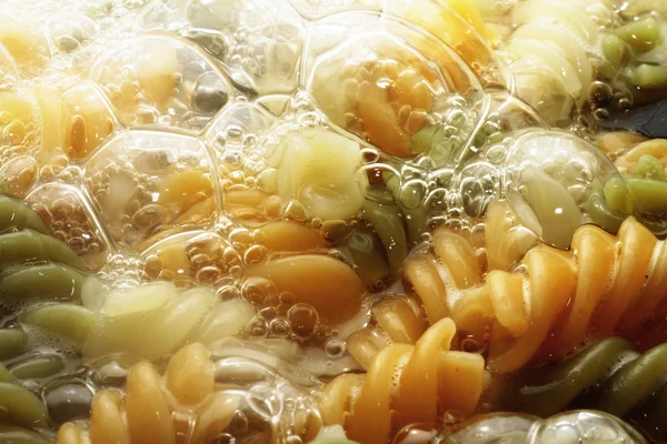 Pastas espirales en agua hirviendo caliente — Foto de Stock