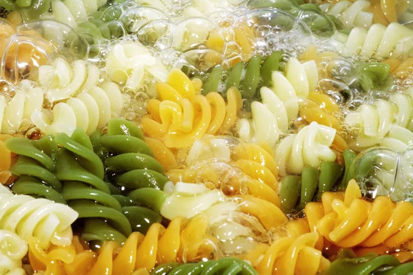 Spiral pasta in boiling hot water Royalty Free Stock Photos
