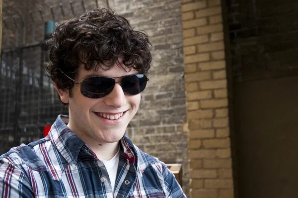 Gülümseyen güneş gözlüğü takan genç adam — Stok fotoğraf