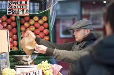 Fruit seller wrapping up products, London, UK, 2011 clipart