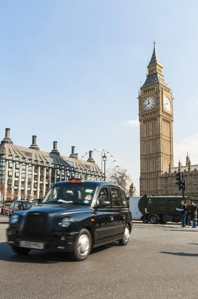 LONDON, UK - APRIL 02: Famous black cab driving by Houses of Par — Stock Photo, Image