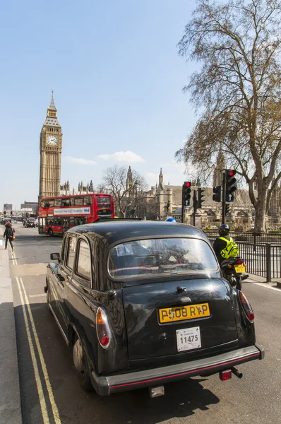 LONDRES, Reino Unido - 02 DE ABRIL: Famoso taxi negro conduciendo por Houses of Par —  Fotos de Stock