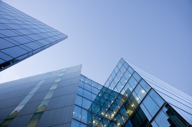 Blue glass buildings on blue sky clipart