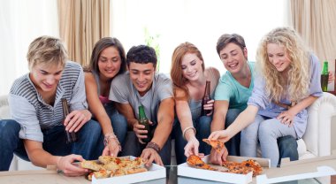 Teenagers eating pizza at home clipart