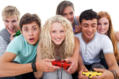 Excited teenagers playing video games in the living-room clipart