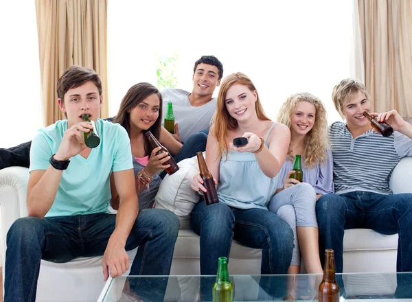 Amigos bebendo cerveja em casa e assistindo tv — Fotografia de Stock