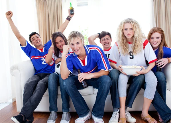 Подростки смотрят футбольный матч дома — стоковое фото