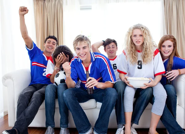 Tieners kijken naar een voetbalwedstrijd in de woonkamer — Stockfoto