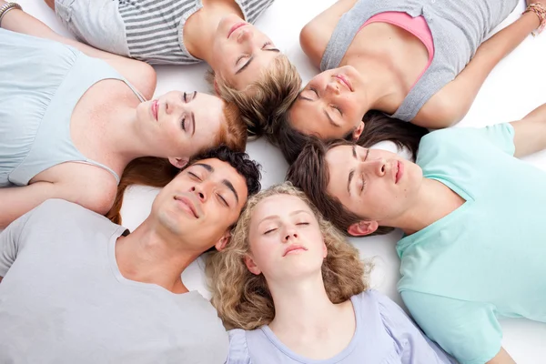 Подростки спят на полу с головами вместе — стоковое фото