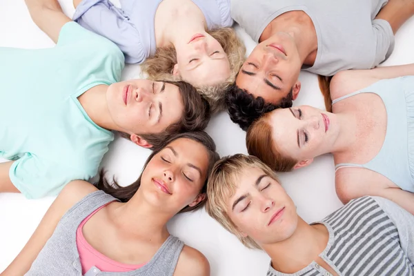 Tieners slapen op de vloer met hoofden samen — Stockfoto