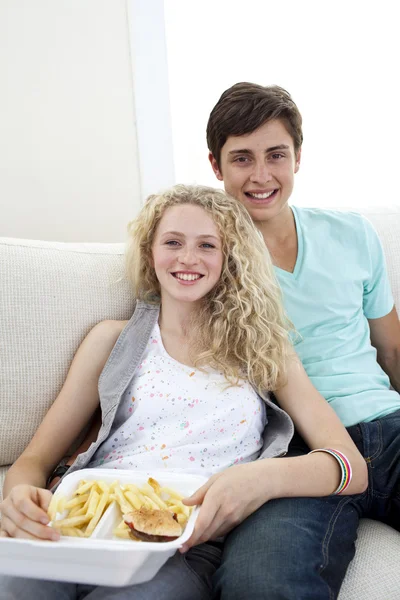 Teen pár jíst hamburgery a hranolky — Stock fotografie