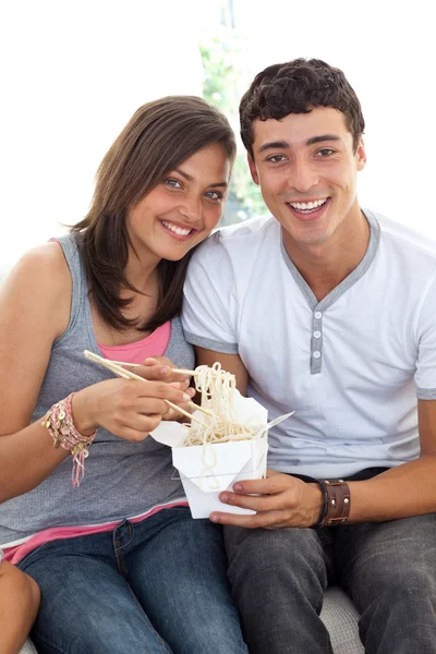 Smiling couple of teenagers eating pasta — Stock Photo, Image