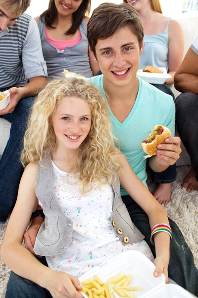 Adolescentes comendo hambúrgueres e batatas fritas — Fotografia de Stock