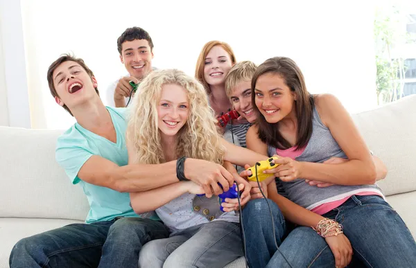 Adolescentes jogando videogames na sala de estar — Fotografia de Stock
