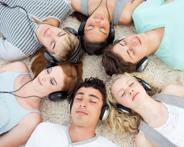 Grupp vänner lyssna på musik på golvet — Stockfoto