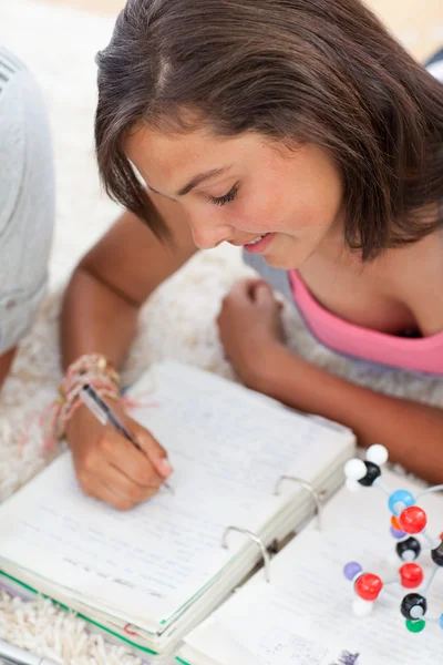 Krásné dospívající dělat domácí úkoly na podlaze — Stock fotografie