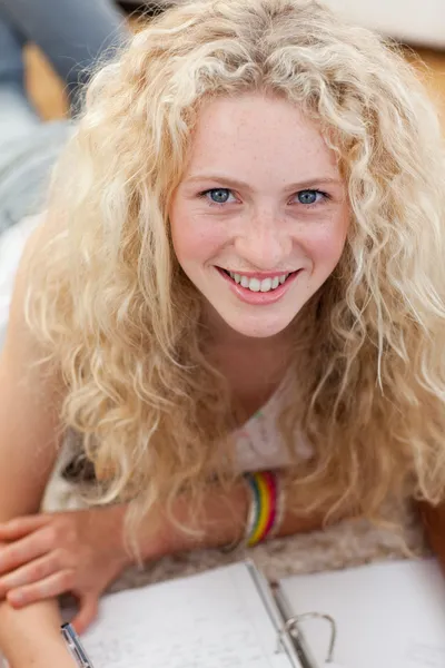 Retrato de un adolescente sonriente estudiando en el suelo — Foto de Stock