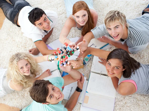 Adolescentes estudando Ciência no chão — Fotografia de Stock