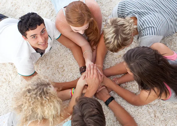 Tonåringar liggande på marken med händerna tillsammans — Stockfoto