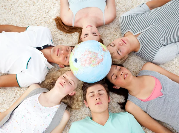 Tieners slapen op de vloer met een terrestrische wereldbol in de — Stockfoto