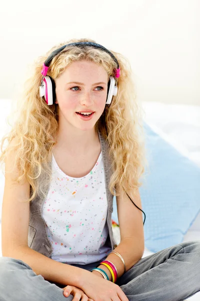 Vacker tonåring lyssnar på musik på sin säng — Stockfoto