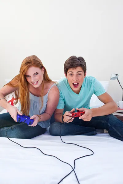 Um casal adolescente animado jogando videogames — Fotografia de Stock