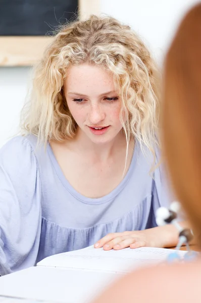 Blonder Teenager macht Hausaufgaben in einer Bibliothek — Stockfoto