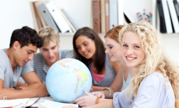 Tieners in een bibliotheek werkt met een terrestrische globe — Stockfoto