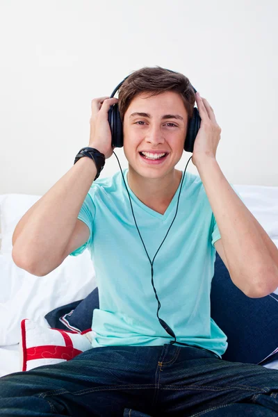 A teenage guy listening to the music in his bedroom — Stock Photo, Image