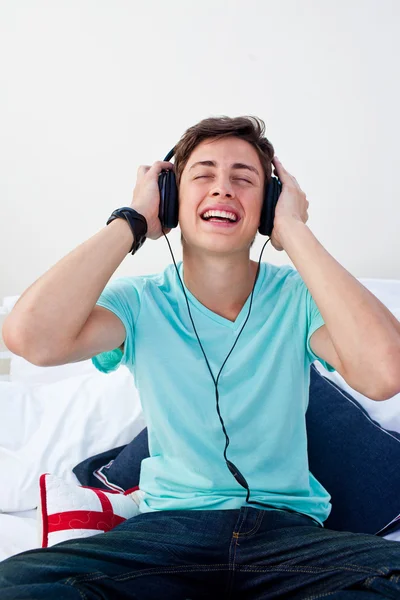 Подросток, сидящий на кровати и слушающий музыку. — стоковое фото
