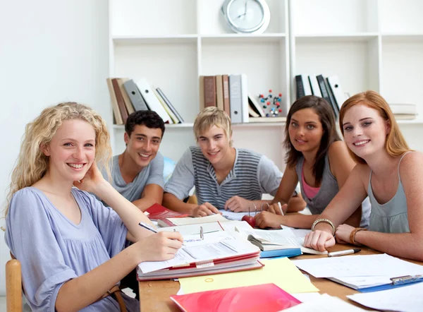 Adolescentes fazendo lição de casa na biblioteca — Fotografia de Stock