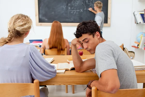 Tired teenager getting bored in a class — Stock Photo, Image