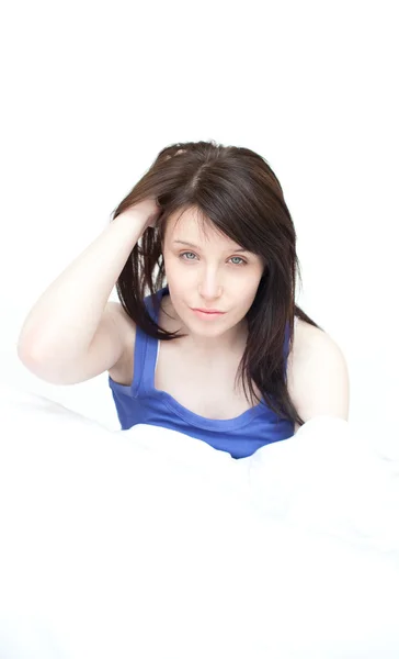 Yorgun, genç bir kadının yatağında oturmuş portre — Stok fotoğraf