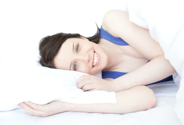 Glad kvinna avkopplande liggande på hennes säng — Stockfoto