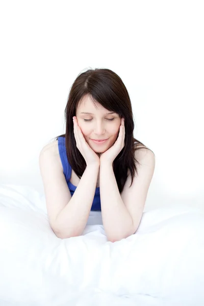 Porträtt av en trött kvinna som sitter på sin säng — Stockfoto