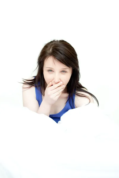 Сияющая женщина зевает сидя на кровати — стоковое фото