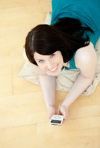 Розслаблена жінка слухає музику, що лежить на підлозі — стокове фото