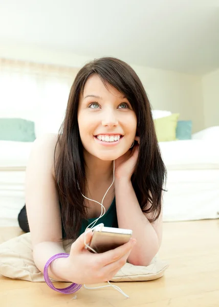 Lovely woman listening music lying on the floor — Stock Photo, Image