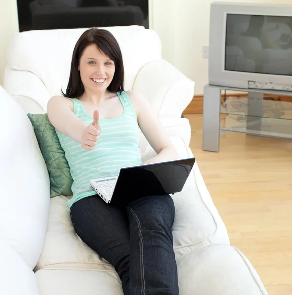 Веселая женщина, сидящая в интернете с большим пальцем вверх — стоковое фото