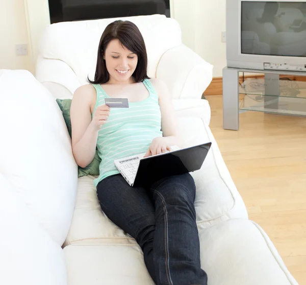 Чарівна жінка купує онлайн лежить на дивані — стокове фото