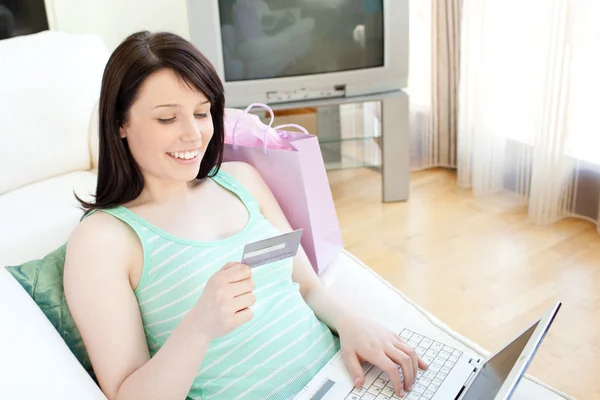 Attraktive junge Frau beim Online-Shopping auf dem Sofa liegend — Stockfoto