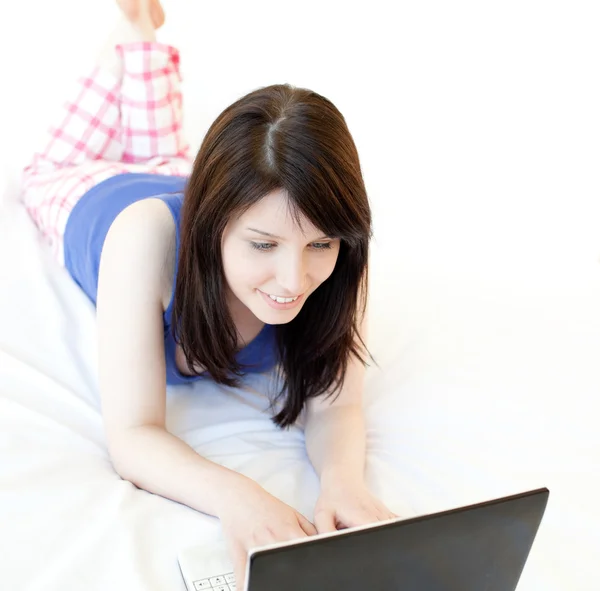 Young woman surfing the internet lying on a bed — Stock Photo, Image