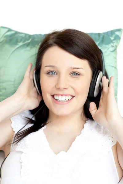 Jolly donna ascoltare musica sdraiata su un divano — Foto Stock
