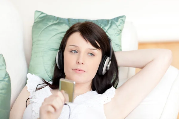 Mooie jonge vrouw luisteren muziek met koptelefoon — Stockfoto