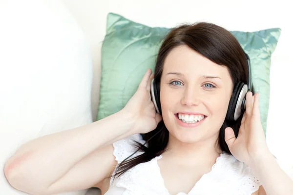 Χαμογελώντας νεαρή γυναίκα ακούγοντας μουσική με ακουστικά — Φωτογραφία Αρχείου