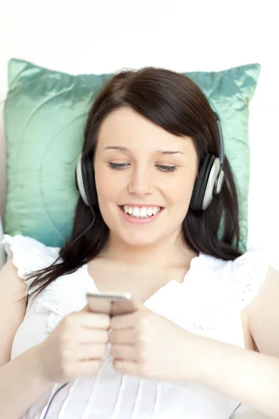 Neşeli genç kadın kulaklık ile müzik dinleme — Stok fotoğraf